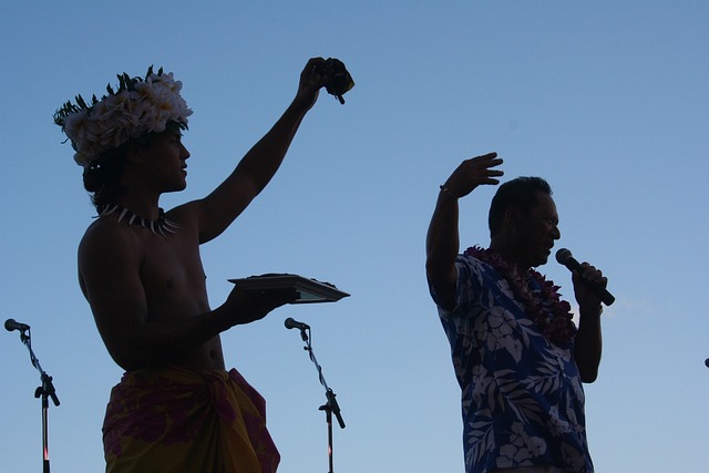 An image showcasing the vibrant colors of a traditional Hawaiian luau: a mesmerizing sunset backdrop with hula dancers swaying gracefully, fire-knife performers in action, and a lavish feast spread out on banana leaves